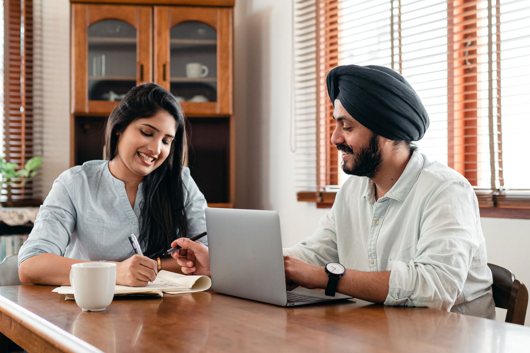 Indian professionals collaborating with a laptop and notebook