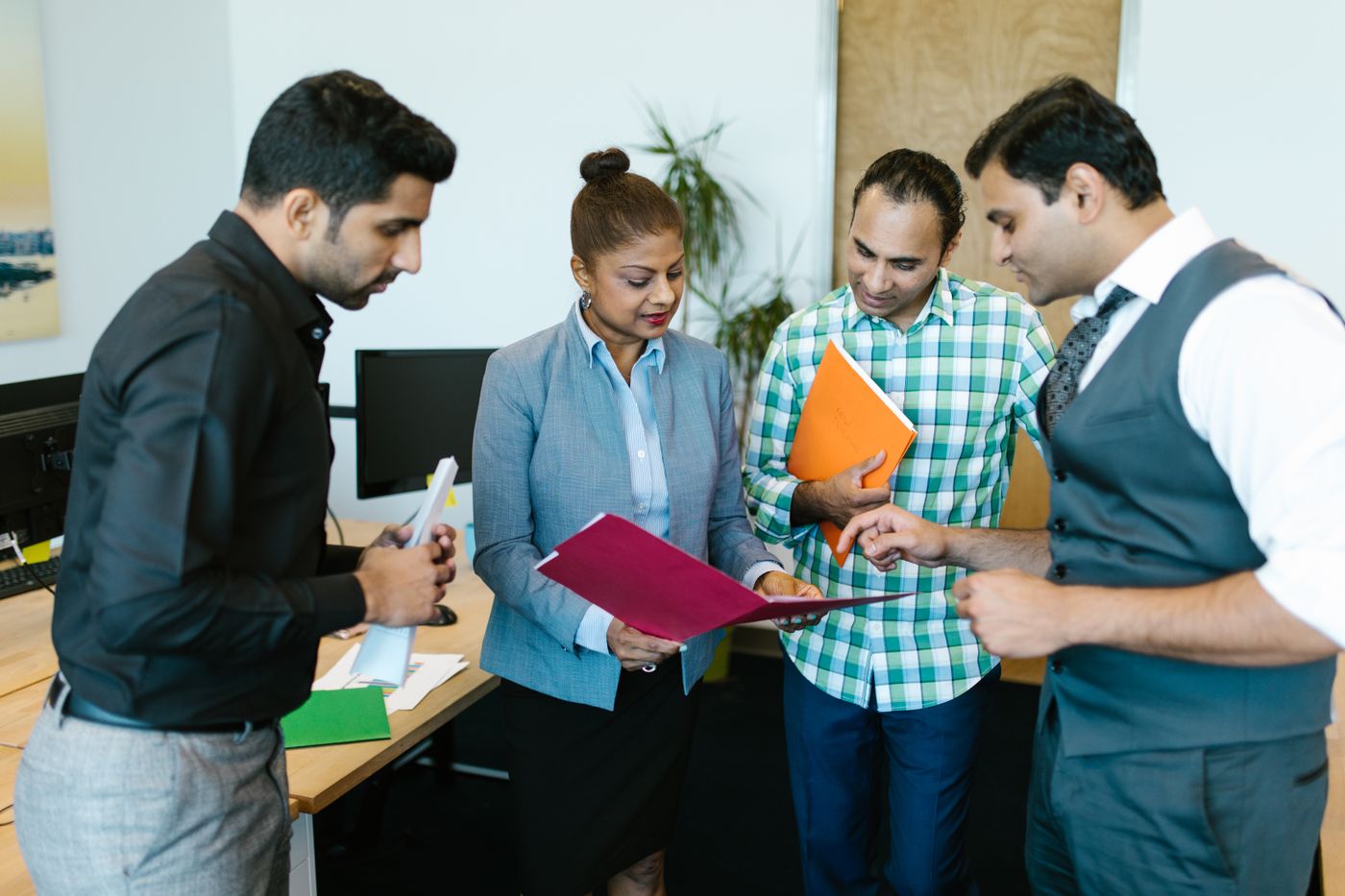 South Asian business team reviewing documents together