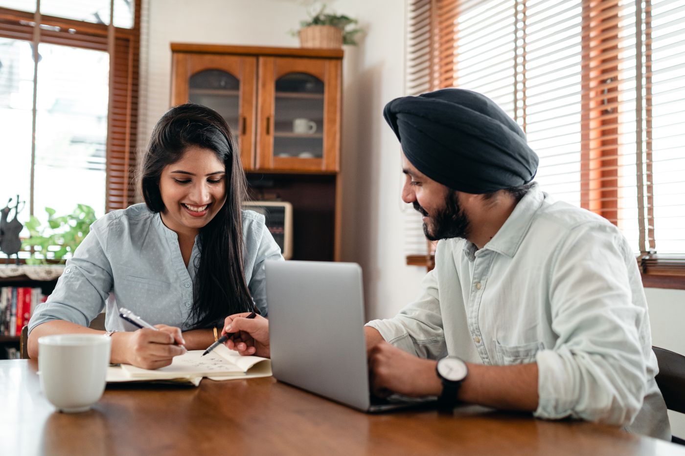 Indian professionals discussing a business decision around a laptop